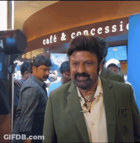 Man In Green Suit By Cafe Sign GIF