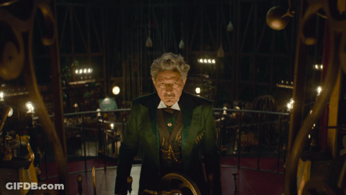 Man In Green Suit Staring In Dark Room GIF