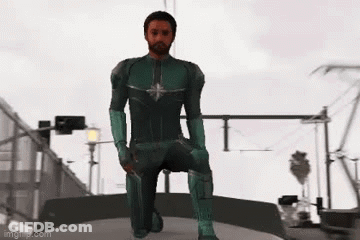 Man In Green Superhero Costume Kneeling On Bridge GIF