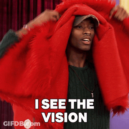 Man In Green Sweater Covering Head With Red Blanket Says I See The Vision GIF