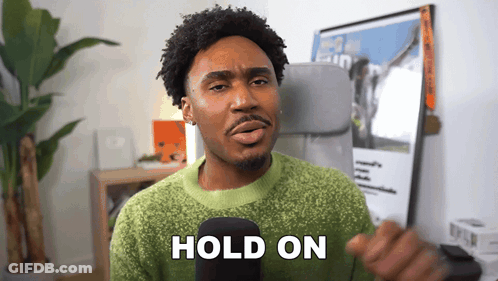 Man In Green Sweater Holding Microphone Saying Hold On GIF