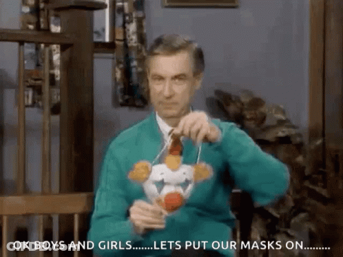 Man In Green Sweater Putting On Mask GIF