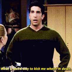 Man In Green Sweater Says What A Weird Way To Kick Me When I'm Down GIF