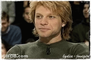 Man In Green Sweater Sitting In Front Of Crowd Canal+ GIF