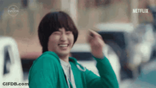 Man In Green Sweater Waving And Laughing GIF