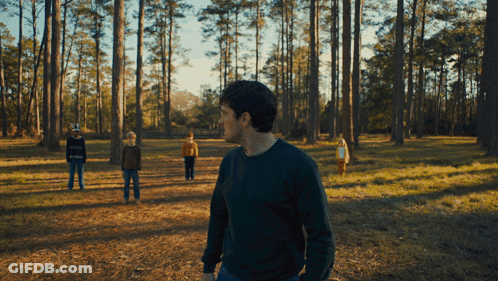 Man In Green Sweater With Three Children In Forest GIF