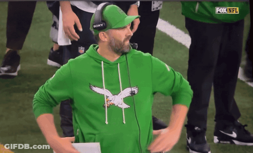 Man In Green Sweatshirt With Eagle And Sony Hat On Football Field GIF