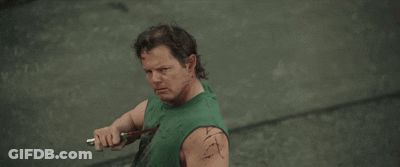 Man In Green Tank Top Holding Knife Smiling GIF