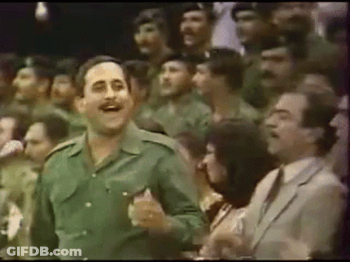 Man In Green Uniform Dancing Before Crowd GIF