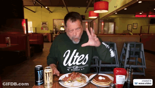Man In Green Utes Shirt Sitting GIF