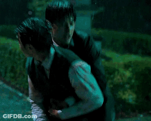 Man In Green Vest Carrying Another Man In Rain GIF