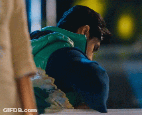 Man In Green Vest Looking Down GIF