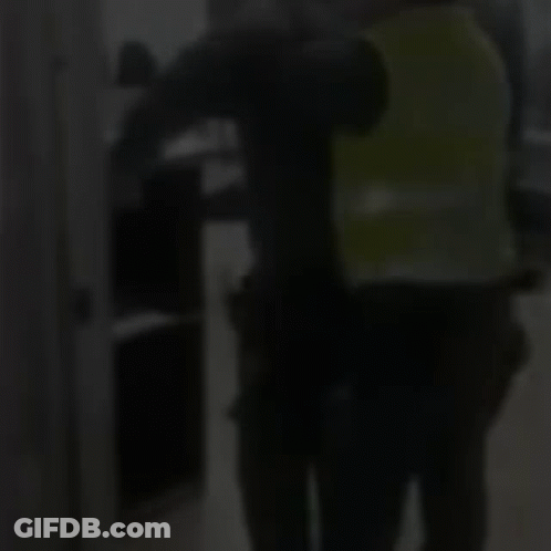 Man In Green Vest Next To Man In Black Shirt GIF