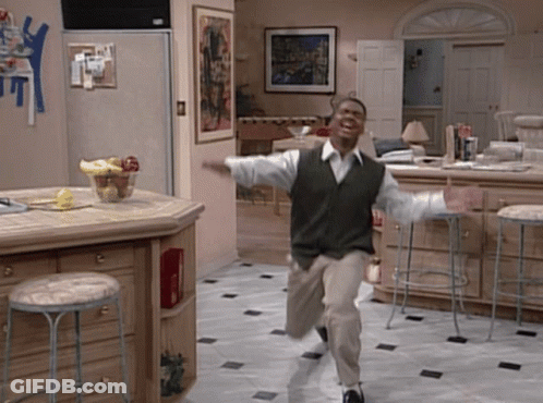 Man In Green Vest Running In Kitchen With Stools GIF