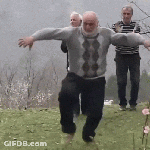 Man In Grey And Black Sweater Dancing In Field GIF