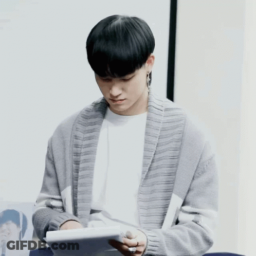 Man In Grey Cardigan Reading Book GIF
