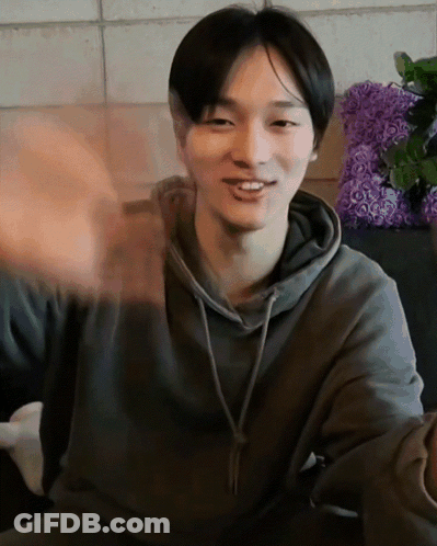 Man In Grey Hoodie Smiling And Waving GIF