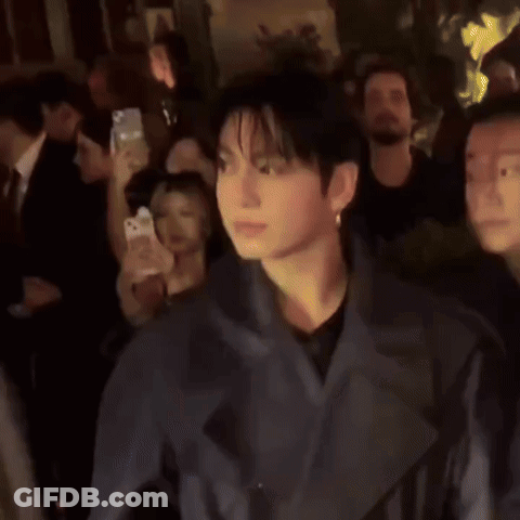 Man In Grey Jacket Standing In Crowd GIF