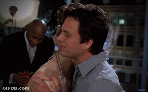 Man In Grey Shirt Hugging Woman In Front Of Man In Suit GIF