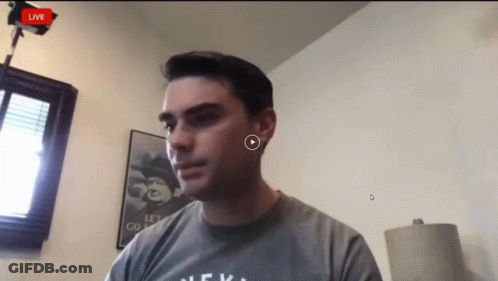 Man In Grey Shirt Looking At Camera GIF