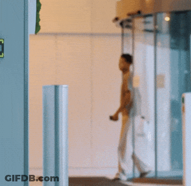 Man In Grey Shirt Walking Through Round Door GIF