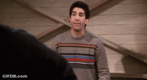 Man In Grey Striped Sweater In Front Of Wooden Wall GIF