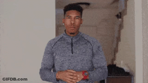 Man In Grey Sweater And Red Watch In Hallway GIF