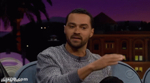 Man In Grey Sweater On Blue Couch Talking GIF