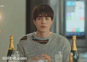Man In Grey Sweater Sitting At Table With Champagne GIF