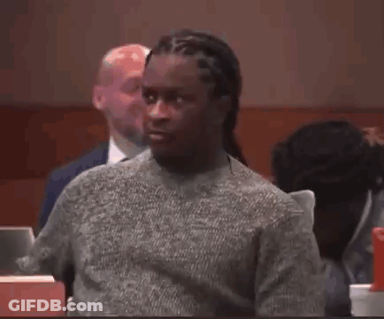 Man In Grey Sweater Sitting In Courtroom GIF