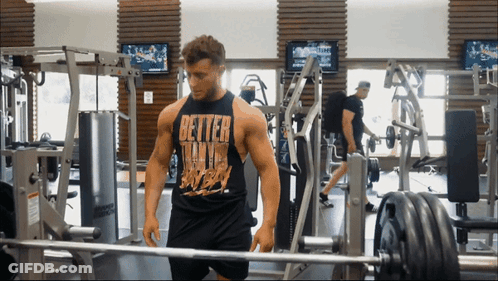 Man In Gym In Black Tank Top Saying Better Than Ever GIF