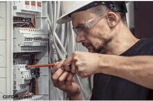 Man In Hard Hat And Safety Glasses Working On Electric Box GIF