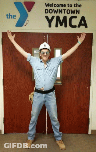 Man In Hard Hat And Sunglasses At YMCA Door Saying Welcome To The Downtown YMCA GIF