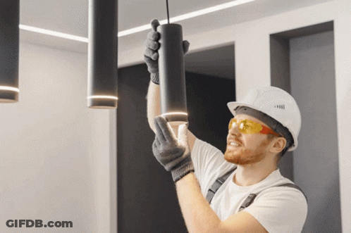 Man In Hard Hat Hanging Light From Ceiling GIF