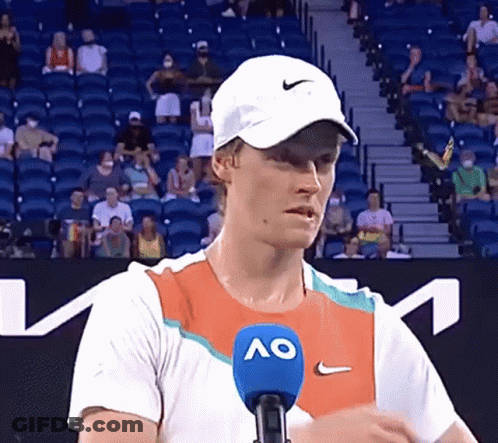 Man In Hat And Ao Shirt Talking Into Microphone GIF