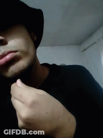Man In Hat And Black Shirt Hand To Chin GIF