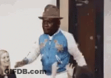 Man In Hat And Blue Jacket Dancing In Front Of Woman GIF