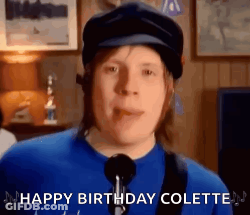 Man In Hat And Blue Shirt Singing Into Microphone GIF