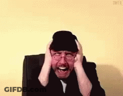 Man In Hat And Glasses Covering Ears GIF