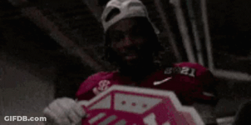 Man In Hat And Gloves Holding Pink Stop Sign GIF