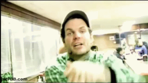 Man In Hat And Green Shirt Making Funny Face In Restaurant GIF
