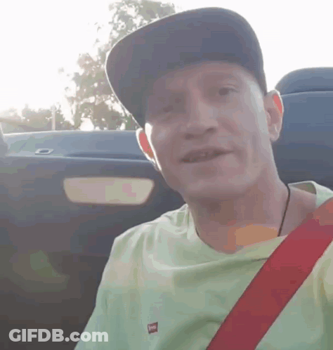 Man In Hat And Green Shirt Smiling In Car GIF