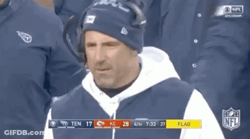 Man In Hat And Hoodie In Front Of NFL Scoreboard GIF