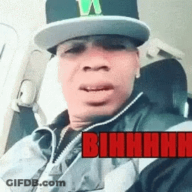 Man In Hat And Jacket In Car With Bihhhh In Red GIF