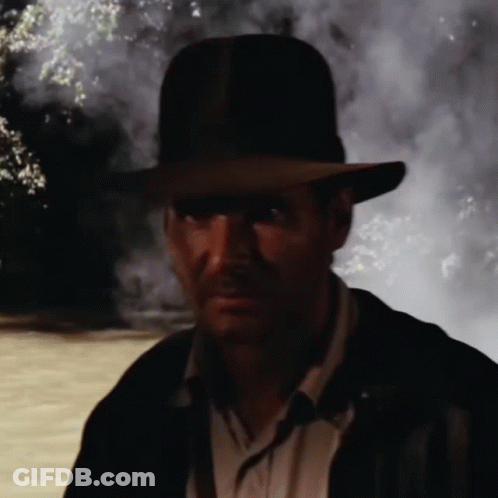Man In Hat And Jacket Standing In Dark GIF