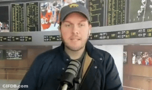 Man In Hat And Jacket Talking Into Microphone GIF