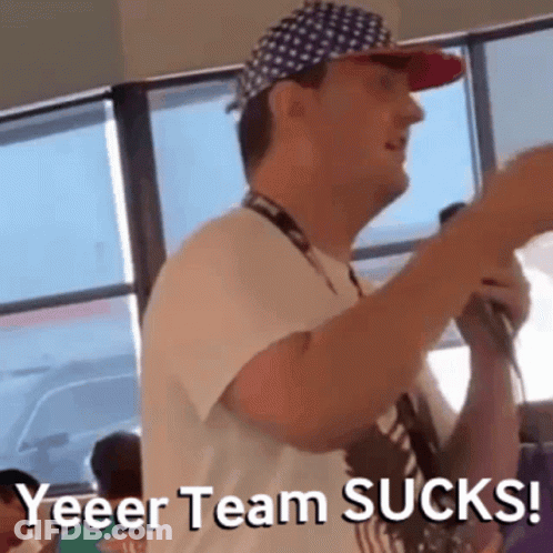 Man In Hat And Lanyard Holding Microphone Says Yeeer Team Sucks GIF