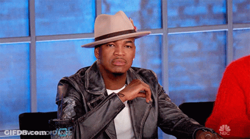 Man In Hat And Leather Jacket In Front Of NBC Sign GIF