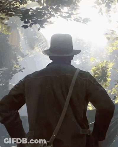 Man In Hat And Leather Jacket Standing In Forest GIF
