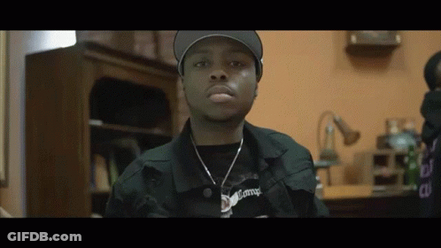 Man In Hat And Necklace Looking At Camera GIF